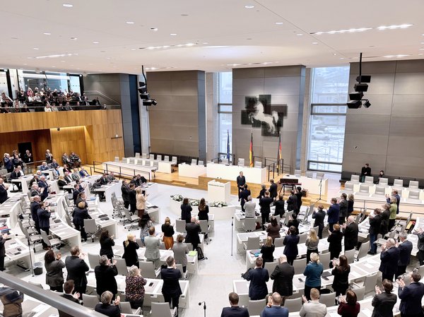 Überblick über den Plenarsaal. Die meisten Zuhörerinnen und Zuhörer sind zum Ende der Rede aufgestanden, während Michel Friedman neben dem Redepult steht.