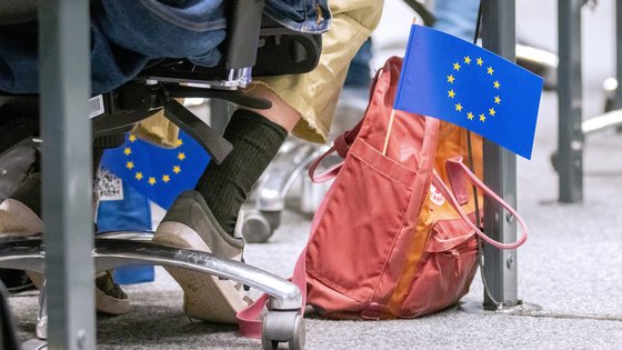 Roter Rucksack auf dem Boden im Forum, heraus ragt eine kleine Europaflagge.