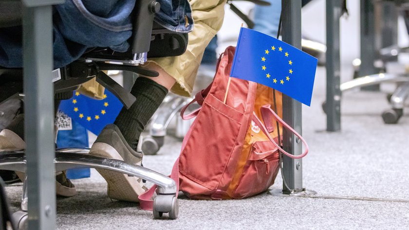 Roter Rucksack auf dem Boden im Forum, heraus ragt eine kleine Europaflagge.