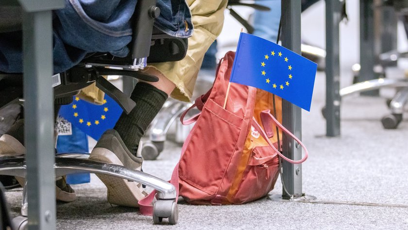 Roter Rucksack auf dem Boden im Forum, heraus ragt eine kleine Europaflagge.