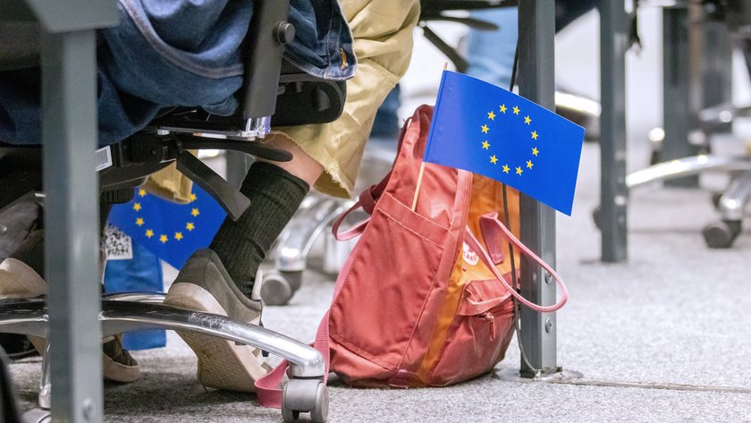 Roter Rucksack auf dem Boden im Forum, heraus ragt eine kleine Europaflagge.