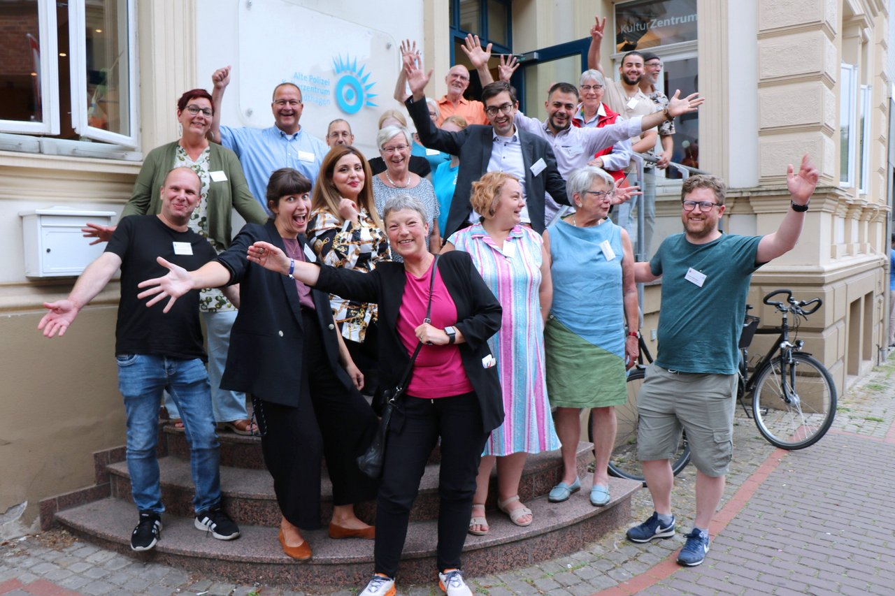 Gruppenfoto vor dem Kulturzentrum Alte Polizei in Stadthagen, alle lachen und gestikulieren.