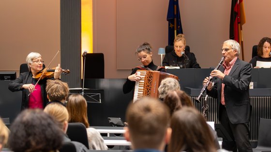 Roswitha Dasch und das Finkelstein Trio musizieren vor einem Publikum aus Schülerinnen und Schülern.