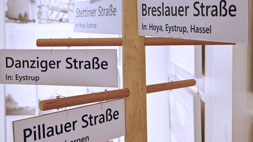 Straßenschilder an einem Holzmast