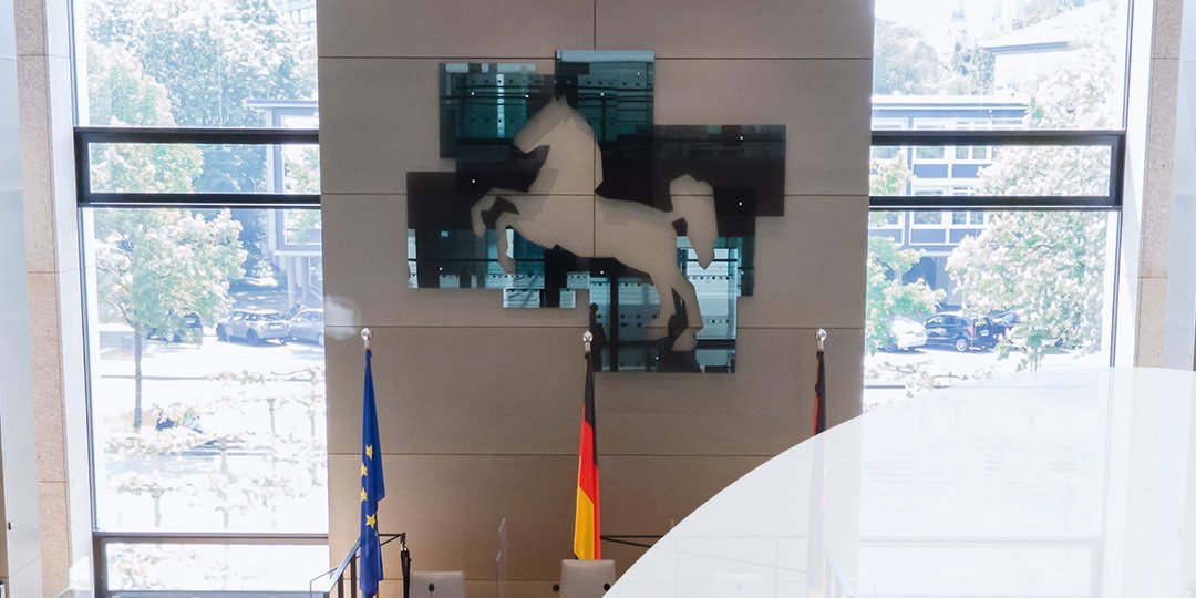 Bild: © Niedersächsischer Landtag; Foto: Stefan Behrens Plenarsaal, darüber das Logo des Niedersächsischen Landtages in abgewandelter Form: Eine 75 ersetzt das Wappen.