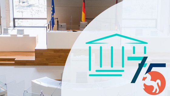 Plenarsaal, darüber das Logo des Niedersächsischen Landtages in abgewandelter Form: Eine 75 ersetzt das Wappen.