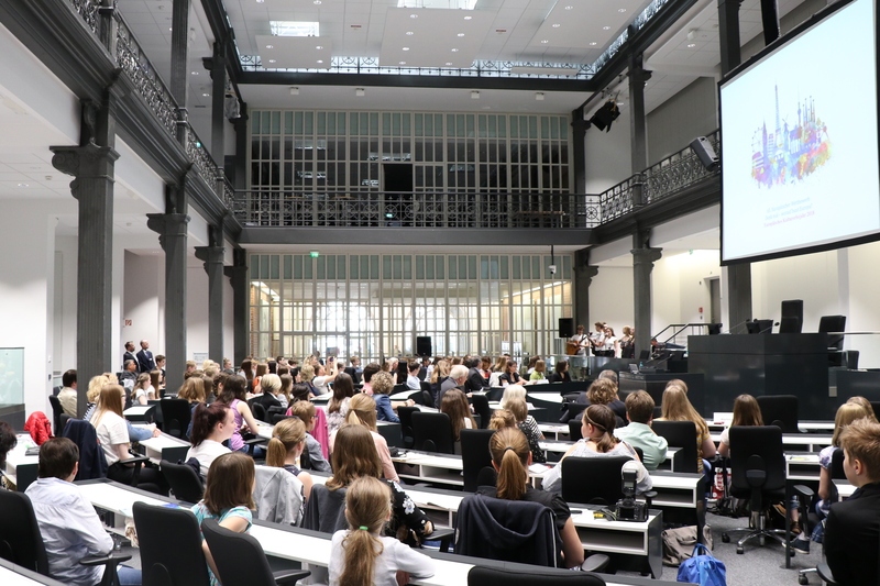 Alle Plätze im Forum des Landtages sind mit Preisträgerinnen und Preisträgern besezt. Die Gäste blicken auf eine große Leinwand.
