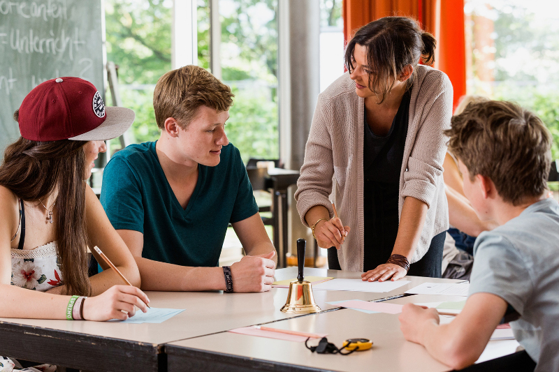 Lehrerin erklärt bei Gruppenarbeit